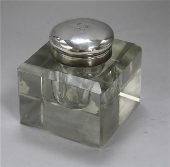 A silver-mounted glass inkwell.